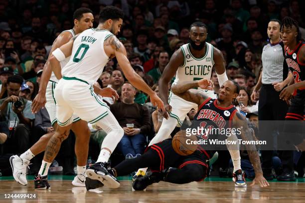 DeMar DeRozan of the Chicago Bulls gets knocked down between Jayson Tatum of the Boston Celtics and Jaylen Brown during the second quarter at TD...