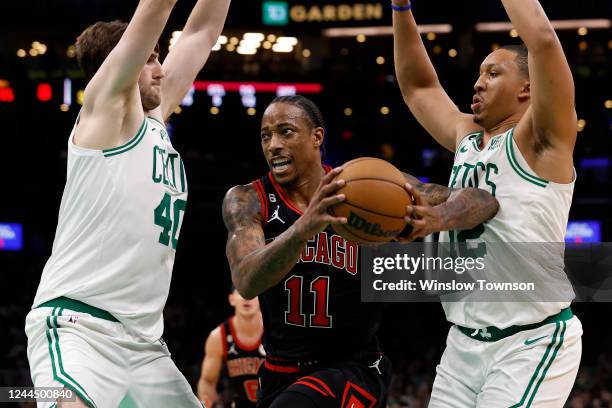 DeMar DeRozan of the Chicago Bulls goes between Luke Kornet of the Boston Celtics and Grant Williams during the second half of the game at TD Garden...
