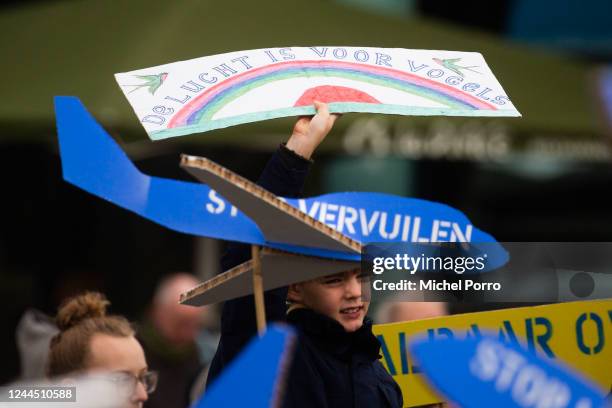 Child holds up a sign reading 'The air is for birds' outside Schiphol Airport on November 5, 2022 in Amsterdam, Netherlands. The group are looking...