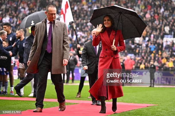 Britain's Catherine, Princess of Wales shelters from the rain under an umbrella after meeting the teams before the 2021 rugby league World Cup men's...