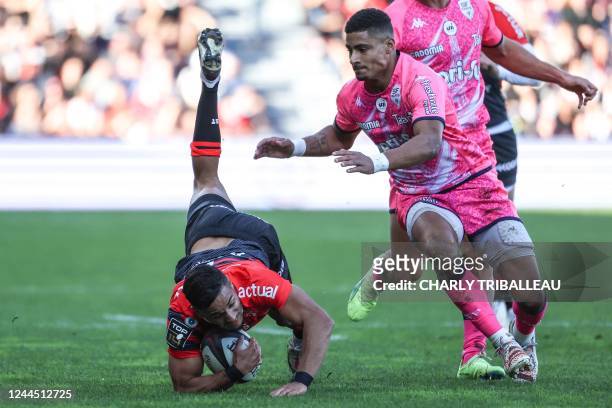 Toulouse's French winger Nelson Epee falls with the ball next to Stade Francais' French wing Stephane Ahmed during the French Top14 rugby union match...