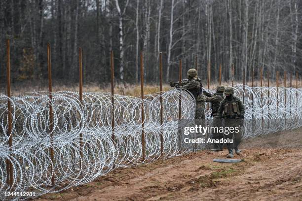 Soldiers of the Polish army carry barbed wire as they construct a barrier on Poland's- Russian exclave Kaliningrad border on November 05, 2022 in...