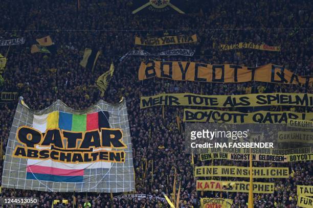 Dortmund fans display banners demanding a boycott of the 2022 FIFA World Cup in Qatar during the German first division Bundesliga football match...
