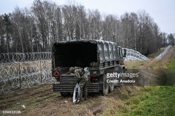 Soldiers of the Polish army carry barbed wire as they construct a barrier on Poland's- Russian exclave Kaliningrad border on November 05, 2022 in...
