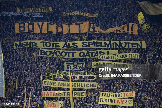 Dortmund fans display banners demanding a boycott of the 2022 FIFA World Cup in Qatar during the German first division Bundesliga football match...