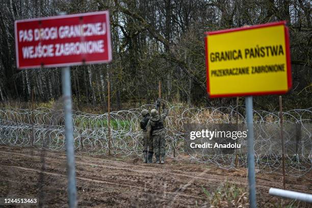 Soldiers of the Polish army carry barbed wire as they construct a barrier on Poland's- Russian exclave Kaliningrad border on November 05, 2022 in...