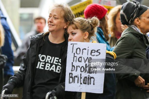 Young person holds a placard as thousands of protesters with placards take part in The People's Assembly National Demonstration - Britain is Broken...