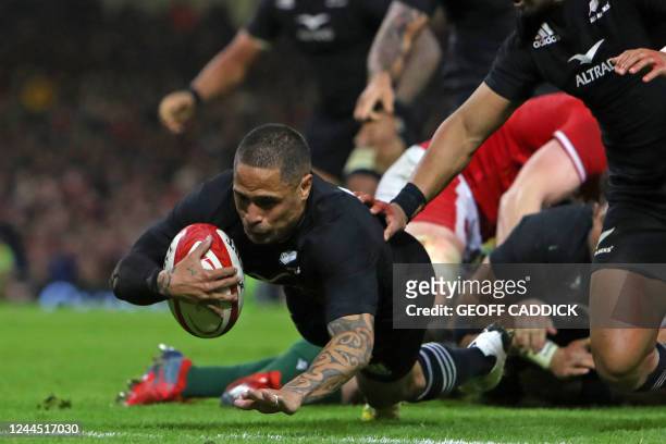 New Zealand's scrum-half Aaron Smith dives over the line to score his second try during the Autumn International rugby union match between Wales and...