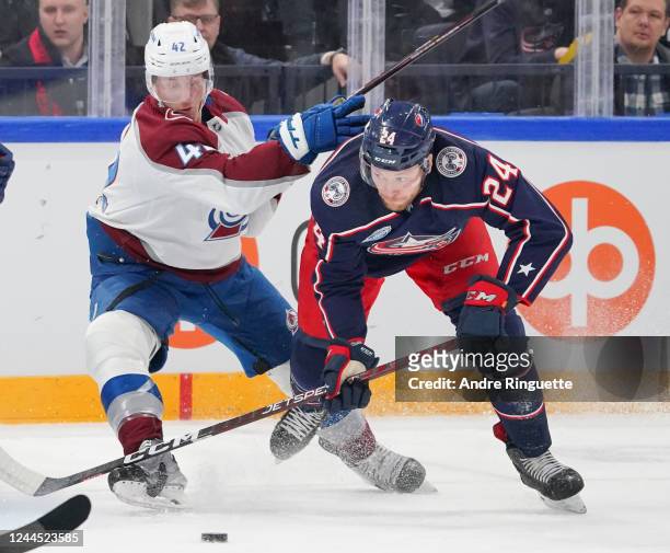 Mathieu Olivier of the Columbus Blue Jackets battles for puck possession against Josh Manson of the Colorado Avalanche battles for puck possession...