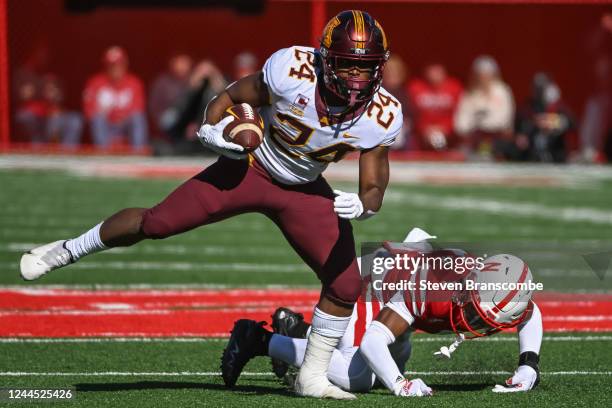 Running back Mohamed Ibrahim of the Minnesota Golden Gophers escapes the tackle of defensive back Marques Buford Jr. #1 of the Nebraska Cornhuskers...