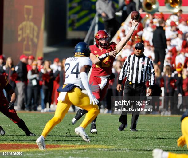 Quarterback Hunter Dekkers of the Iowa State Cyclones throws the ball under pressure from safety Marcis Floyd of the West Virginia Mountaineers in...