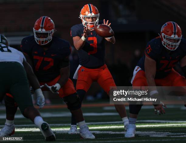 Tommy DeVito of the Illinois Fighting Illini catches the hiked ball during the first half against the Michigan State Spartans at Memorial Stadium on...