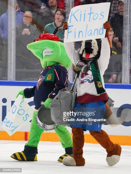 Stinger of the Columbus Blue Jackets and Bernie the St. Bernard hold up a sign thanking the fans after the game during the 2022 NHL Global Series...