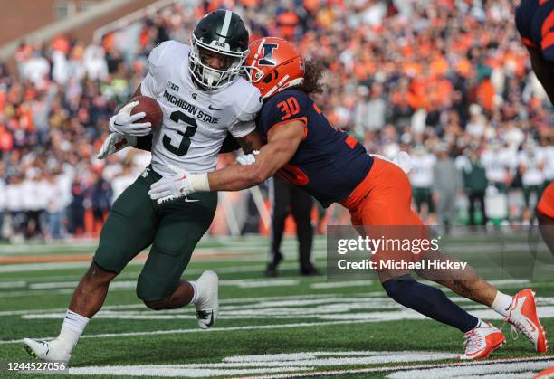 Jarek Broussard of the Michigan State Spartans runs the ball as Sydney Brown of the Illinois Fighting Illini makes the stop during the first half at...