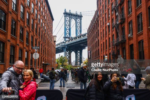 Tourists take pictures with Manhattan Bridge at Dumbo area in Brooklyn, New York, United States, on October 24, 2022. The bridge, designed by Leon...