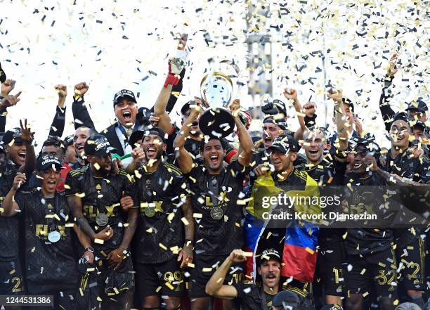 Carlos Vela of Los Angeles FC lifts the championship trophy as he celebrates with teammates during the 2022 MLS Cup Final at Banc of California...