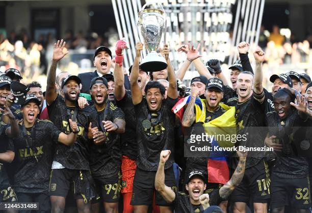 Carlos Vela of Los Angeles FC lifts the championship trophy as he celebrates with teammates during the 2022 MLS Cup Final at Banc of California...