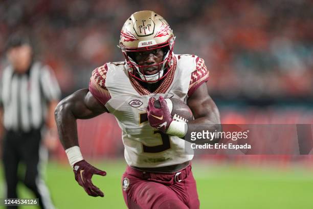 Trey Benson of the Florida State Seminoles rushes for a touchdown during the second quarter against the Miami Hurricanes at Hard Rock Stadium on...
