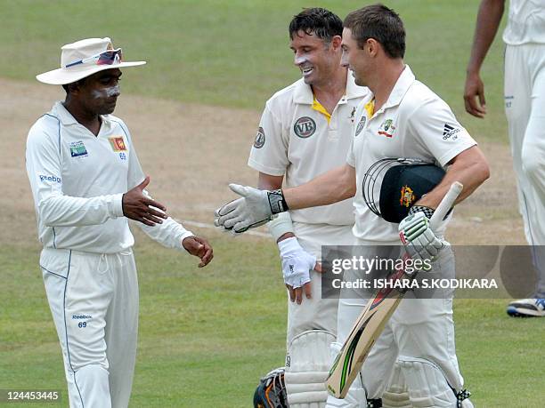 Sri Lankan cricketer Mahela Jayawardene congratulates Australian cricketer Shaun Marsh after he scored a century as Michael Hussey looks on during...