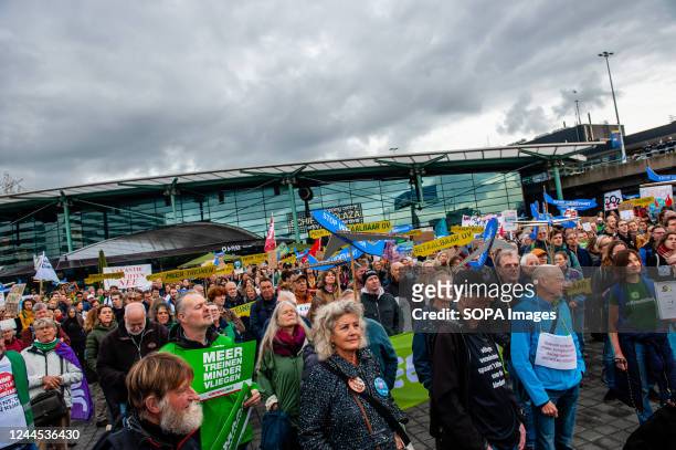Climate activists are seen listening to speeches outside of the airport during the demonstration. Hundreds of climate activists gathered outside of...