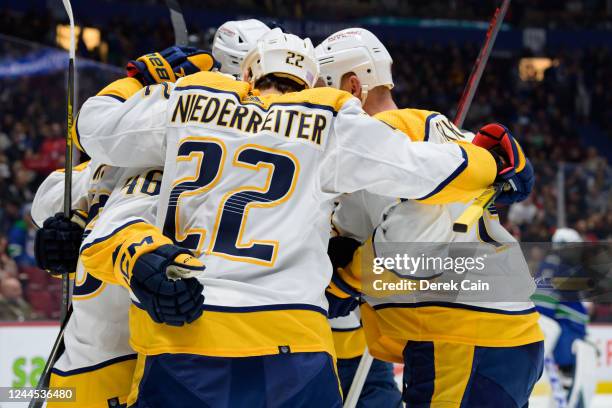 Jordan Gross is congratulated by Mattias Ekholm and Nino Niederreiter of the Nashville Predators after scoring a goal on Thatcher Demko of the...