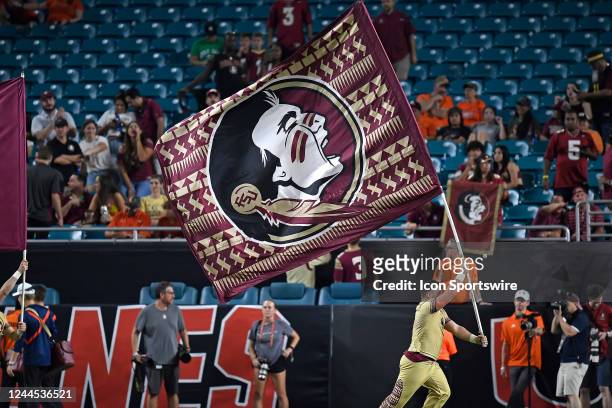Empty seats are visible behind an FSU cheerleaders who ran the Seminoles flag onto the field after a touchdown in the four quarter, as the Miami...