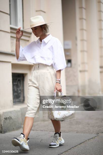 Karin Teigl wearing Arket pants, Louis Vuitton Archlight sneaker and bag, Weekday shirt and Lack of Colors hat on May 31, 2020 in Augsburg, Germany.