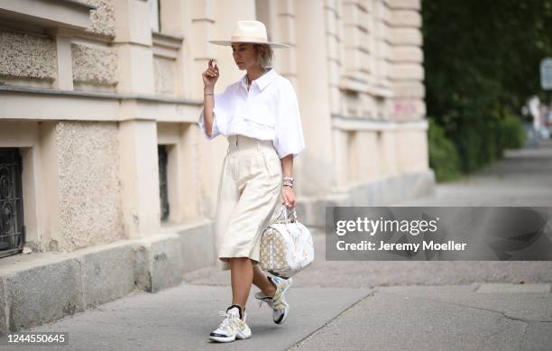 Karin Teigl wearing Arket pants, Louis Vuitton Archlight sneaker and bag, Weekday shirt and Lack of Colors hat on May 31, 2020 in Augsburg, Germany.