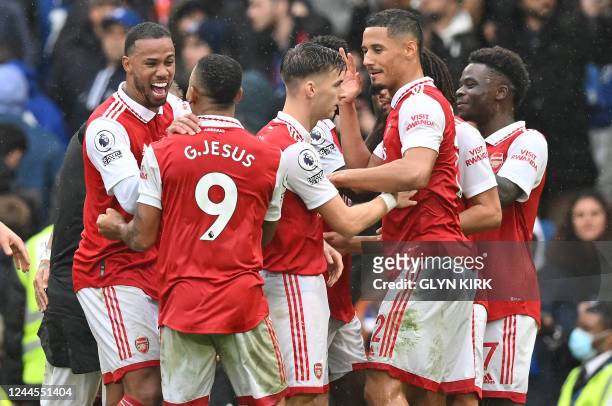 Arsenal players celebrate after the final whistle of the English Premier League football match between Chelsea and Arsenal at Stamford Bridge in...