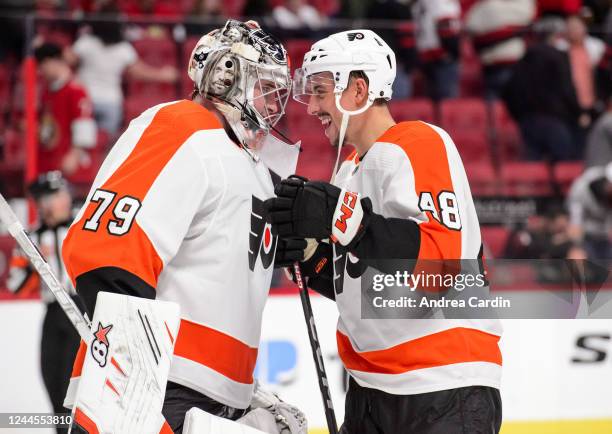 Carter Hart and Morgan Frost of the Philadelphia Flyers celebrate their 2-1 win against the Ottawa Senators at Canadian Tire Centre on November 5,...