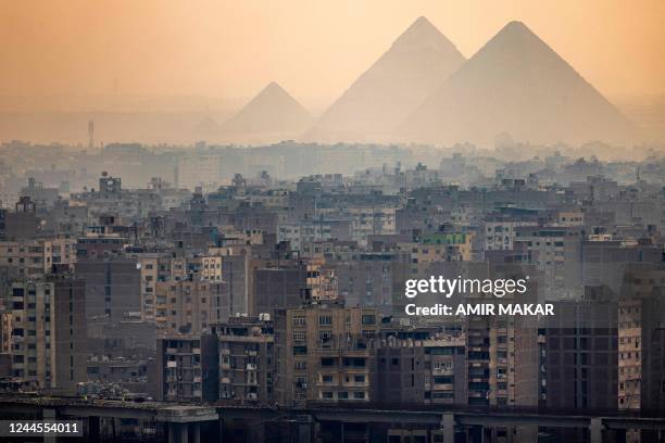 This picture taken on November 1, 2022 shows a view of the skyline of Giza, the twin-city of Egypt's capital, with the Great Pyramid of Khufu, the...