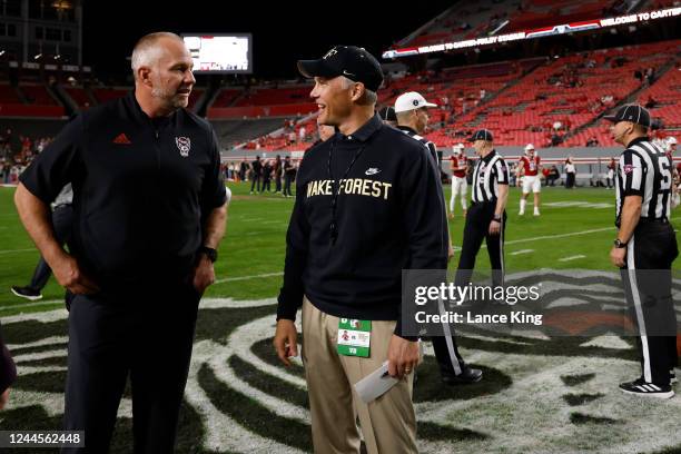 Head coach Dave Doeren of the North Carolina State Wolfpack talks with head coach Dave Clawson of the Wake Forest Demon Deacons prior to their game...