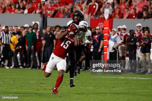 Keyon Lesane of the North Carolina State Wolfpack catches a pass against Caelen Carson of the Wake Forest Demon Deacons at Carter-Finley Stadium on...