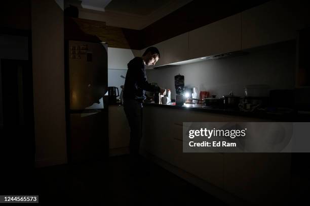 Worker Igor, who normally uses en electric hob, makes tea using a camping stove in his apartment block in near total darkness during a scheduled...