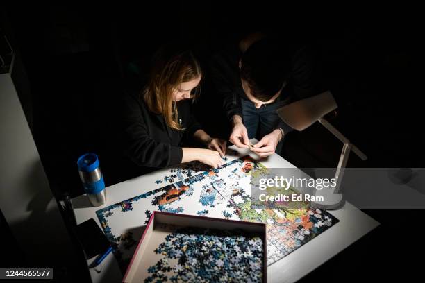 Workers Alina and Igor try to complete a jigsaw puzzle in their apartment block in near total darkness during a scheduled power cut on the left bank...