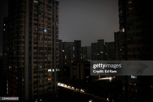 Cars drive between apartment blocks in near total darkness during a scheduled power cut on the left bank of the River Dnipro November 06, 2022 in...