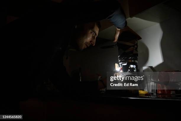 Worker Igor, who normally uses en electric hob, makes tea using a camping stove in his apartment block in near total darkness during a scheduled...