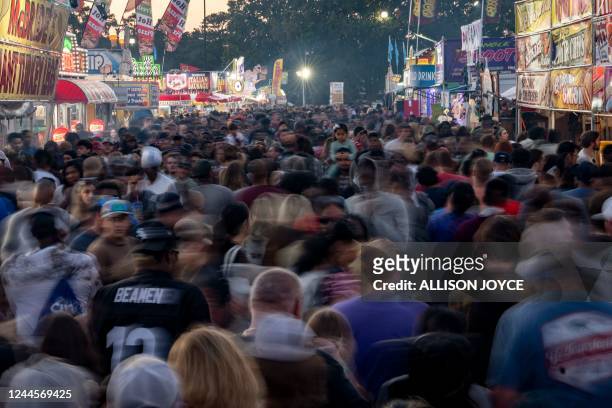 This picture shows the crowd at the North Carolina State Fair on October 15 in Raleigh, North Carolina. - The global population will breach the...