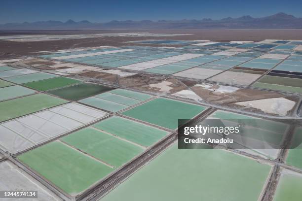 Huge pools of brine containing lithium carbonate and mounds of salt by-products stretch across a lithium mine in the Atacama Desert in Salar de...
