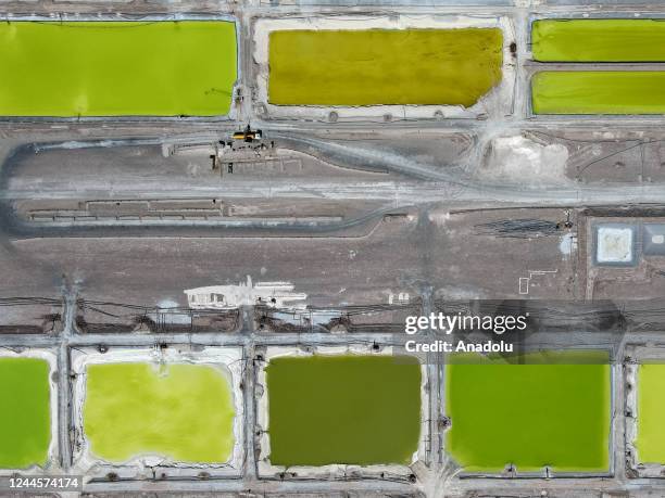 Huge pools of brine containing lithium carbonate and mounds of salt by-products stretch across a lithium mine in the Atacama Desert in Salar de...