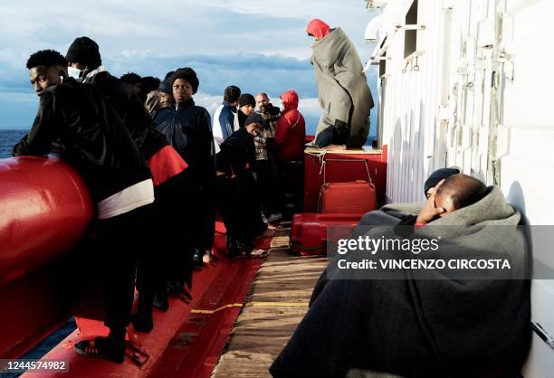 Migrants look on and wait on the deck of the "Ocean Viking" rescue ship of European maritime-humanitarian organisation "SOS Mediterranee" in the Gulf...