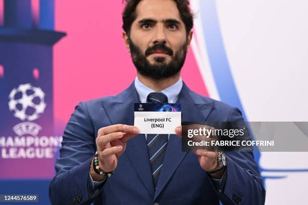 Champions League's ambassador Turkish former footballer Hamit Altintop shows the paper slip of Liverpool FC during the draw for the round of 16 of...