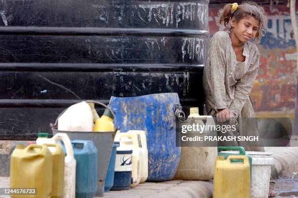 Girl collects drinking water from a tank at a slum on the banks of the Yamuna river in New Delhi, 03 September , 2002. The 10-day UN World Summit has...