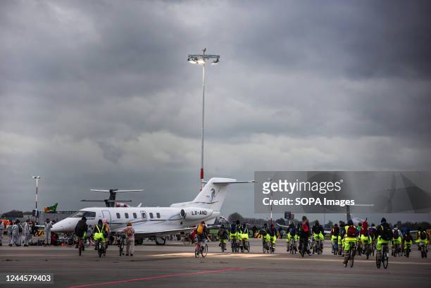 Activists ride bikes as they circle the private jets at Schiphol-East Airport during the climate demonstration. More than 200 Extinction Rebellion...