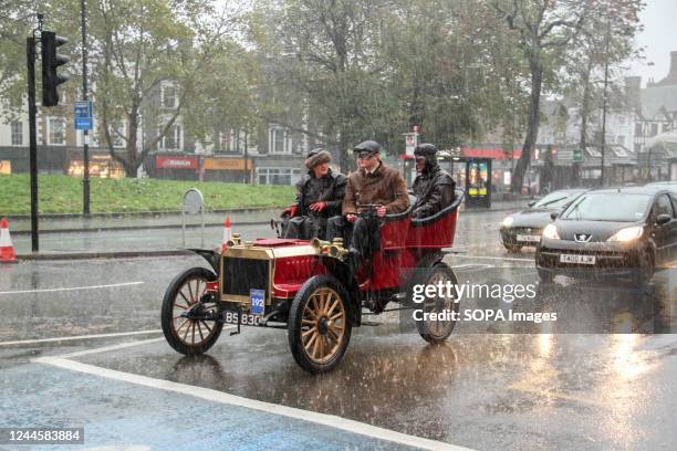 Autocar veteran car no.192 and its passengers endure the rain during a stop at traffic at Clapham Common. More than 350 veteran cars took part in the...