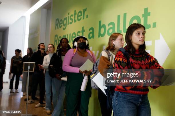 People line up to cast their early ballots for the 2022 general election at the Ann Arbor, Michigan city clerk's satellite office on the campus of...