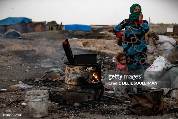 Displaced Syrian woman and a child stand at the Sahlat al-Banat camp for displaced people in the countryside of Raqa in northern Syria on November 7,...