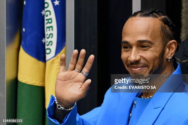 British F1 driver Lewis Hamilton waves at the audience after being awarded the Honorary Brazilian Citizenship, during a ceremony at the National...