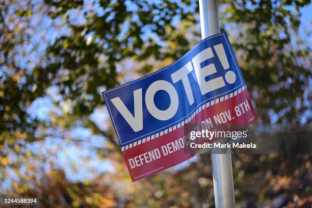 Placard that states "VOTE DEFEND DEMOCRACY on NOV. 8th" affixes to street pole the day before the midterm general election on November 7, 2022 in...