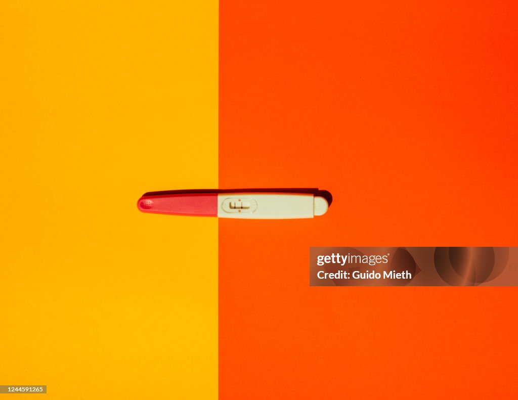 Pregnancy test on yellow background.